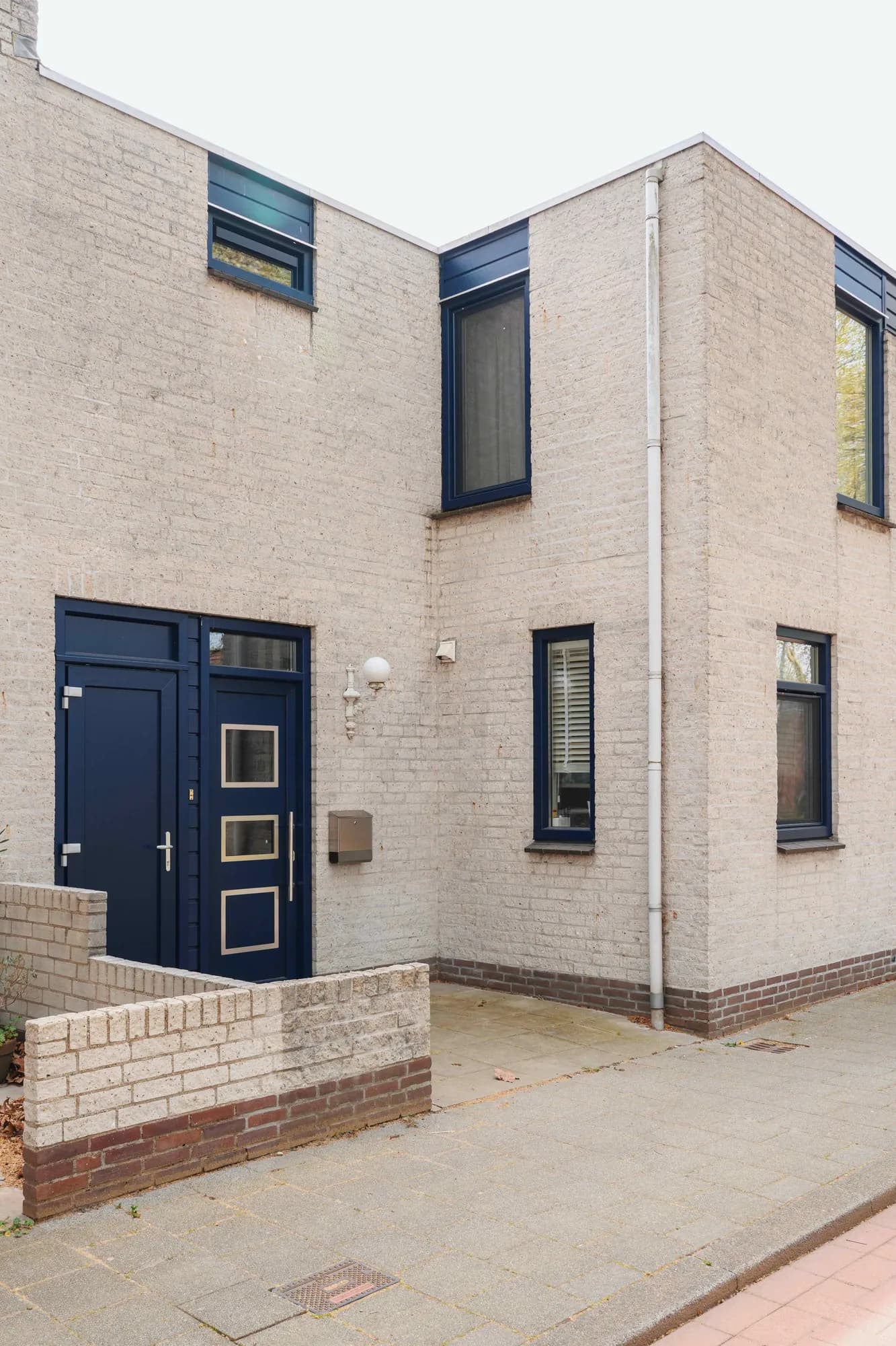 Verticale opname van de donkerblauwe voordeur en zijramen