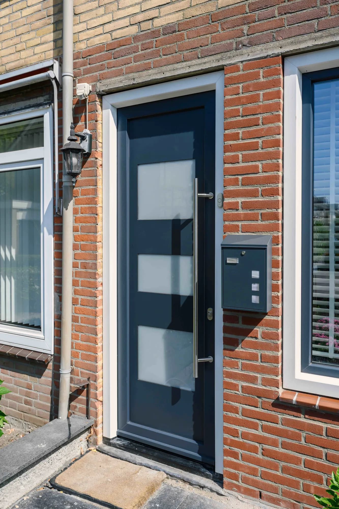 Verticale opname van de entree en kozijnen in lichte baksteen