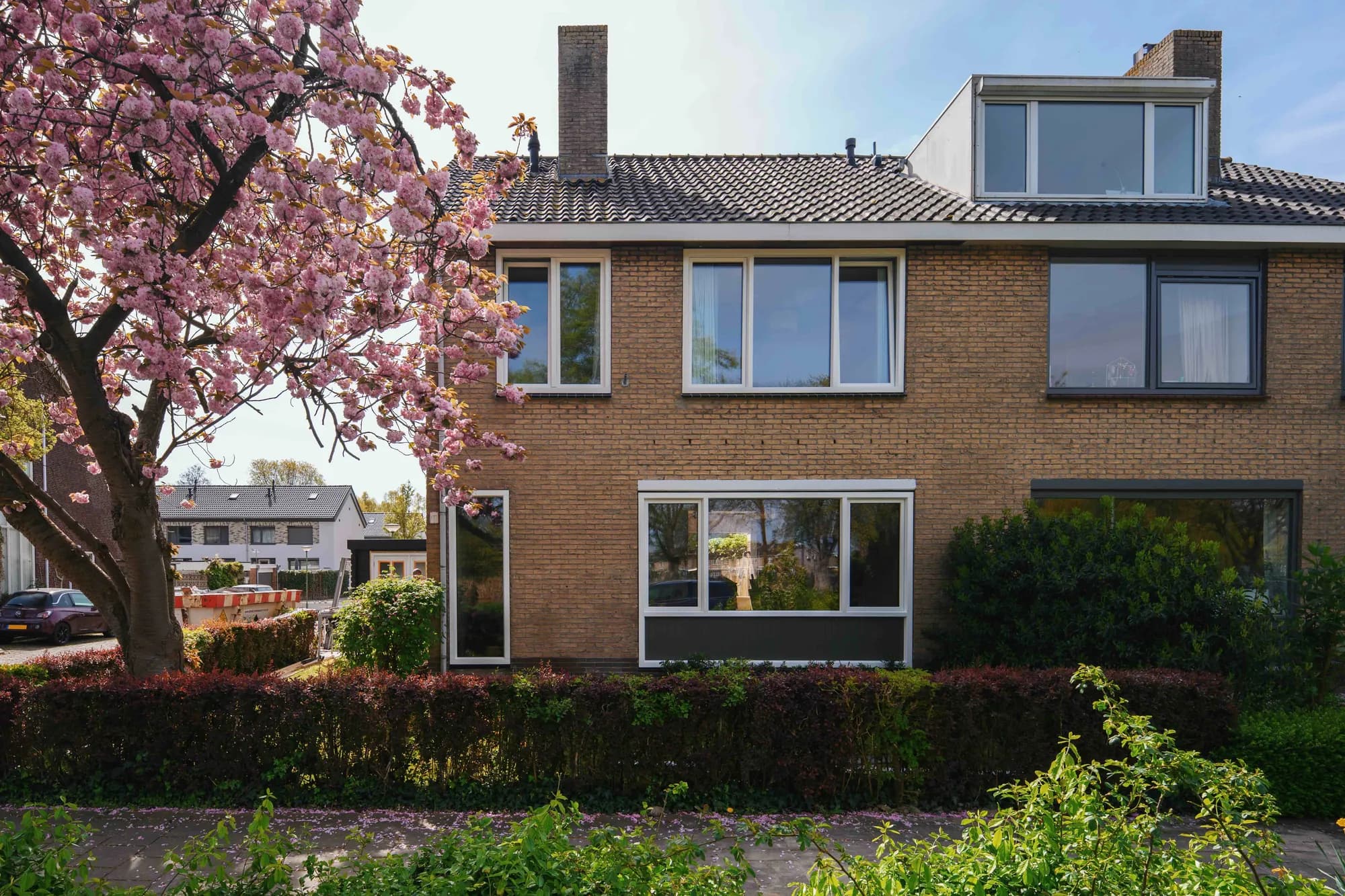 Woning in Dordrecht met nieuwe witte kozijnen en bloesemboom