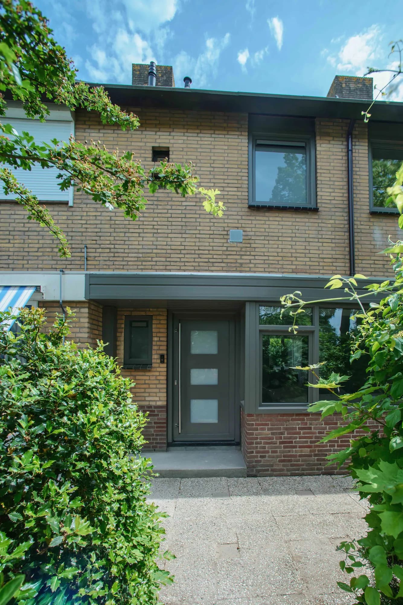 Verticale opname van de donkere kozijnen aan de voorgevel
