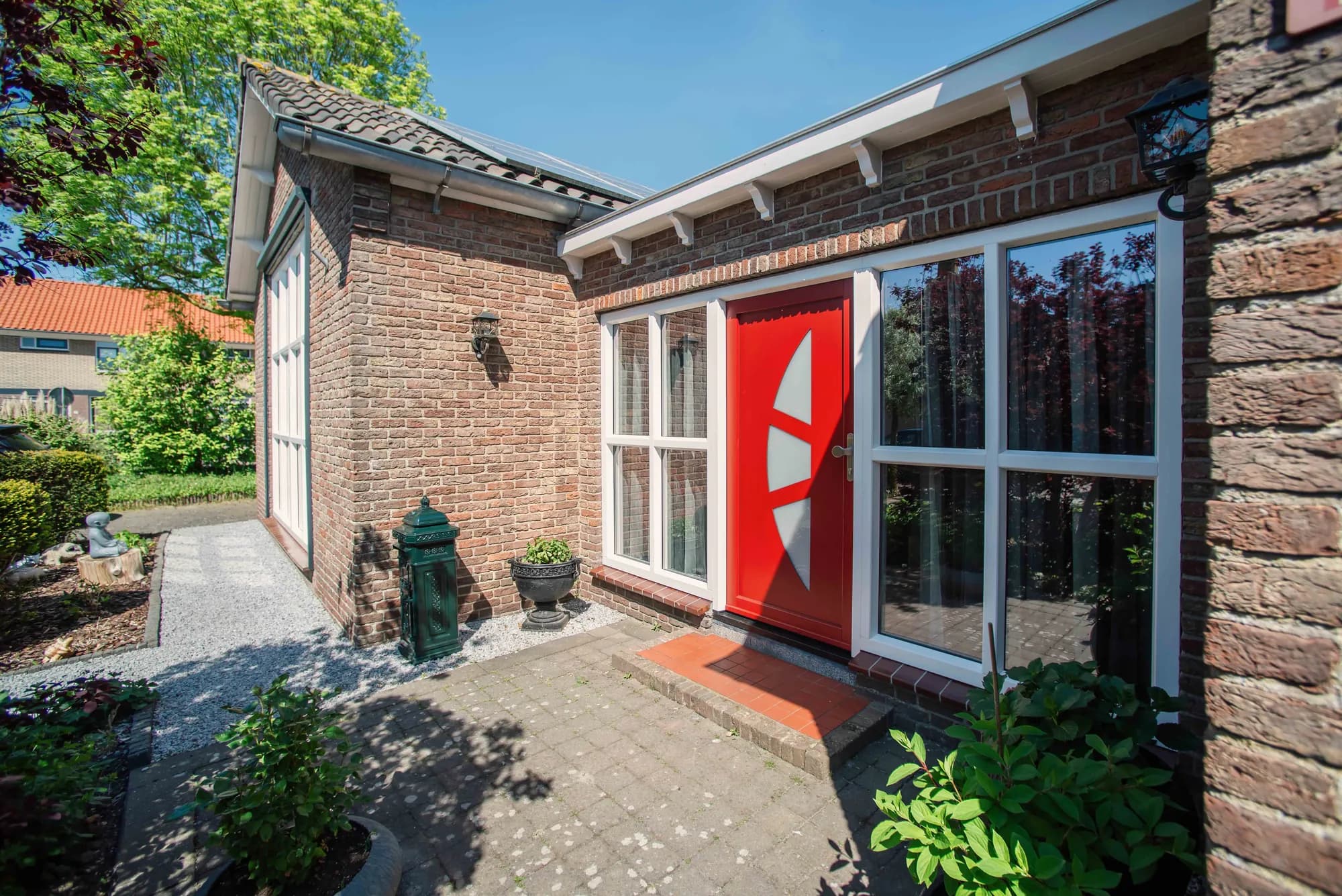 Vrijstaande woning in Piershil met witte kozijnen en rode voordeur