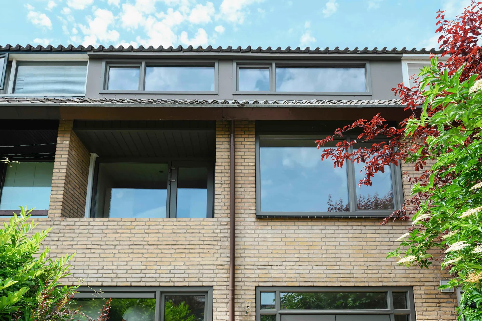 Donkere kozijnen op de bovenverdieping aan de achterzijde