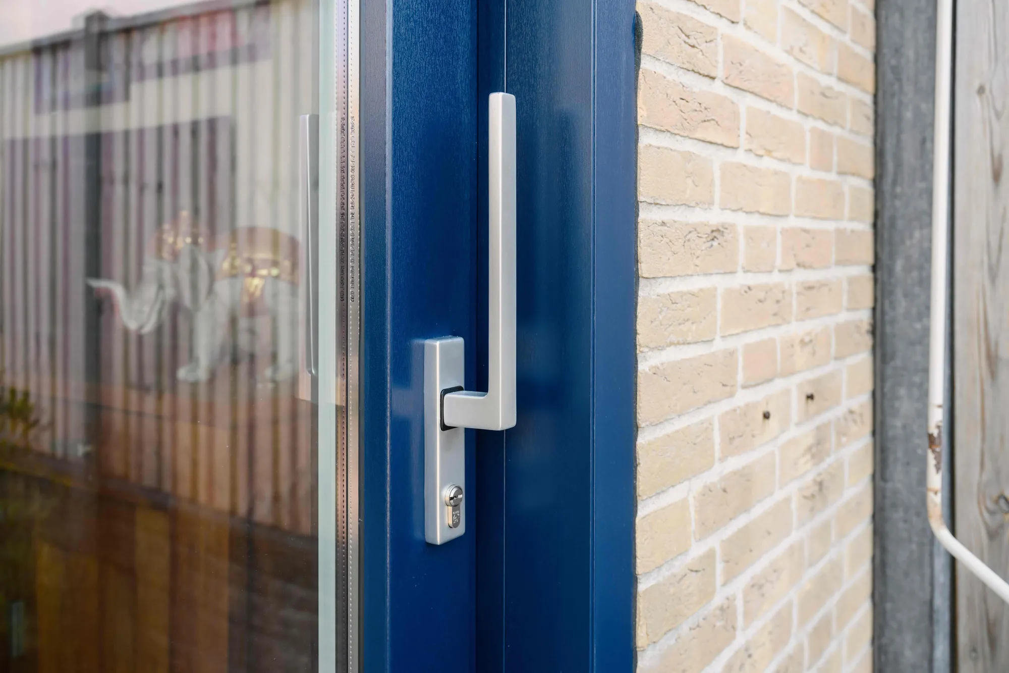 Detail van de donkerblauwe schuifpui en aangrenzend raam