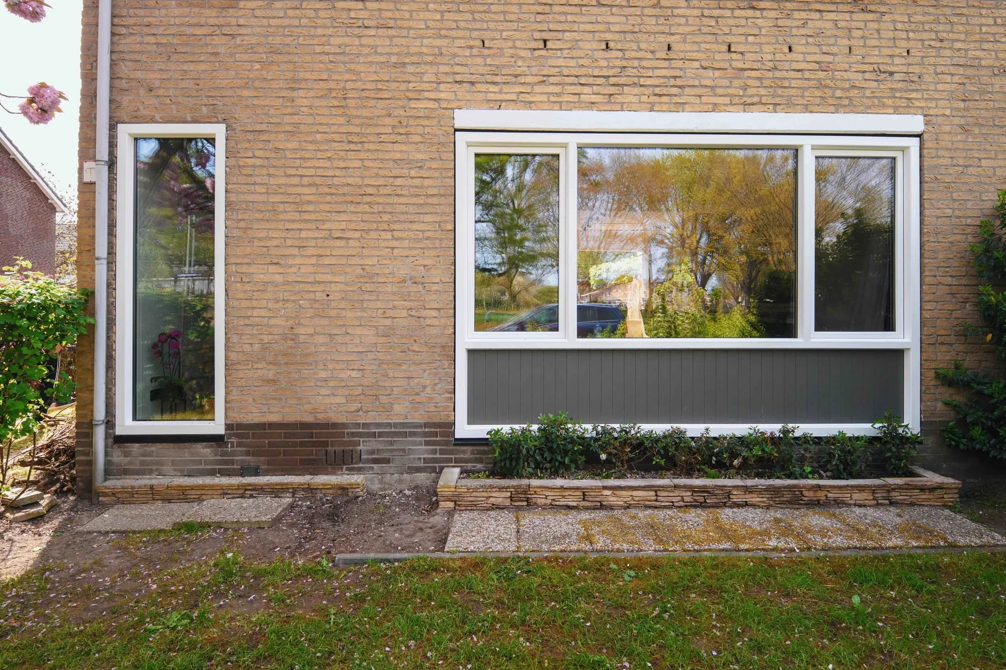 Nieuwe witte kozijnen gezien vanuit de voortuin