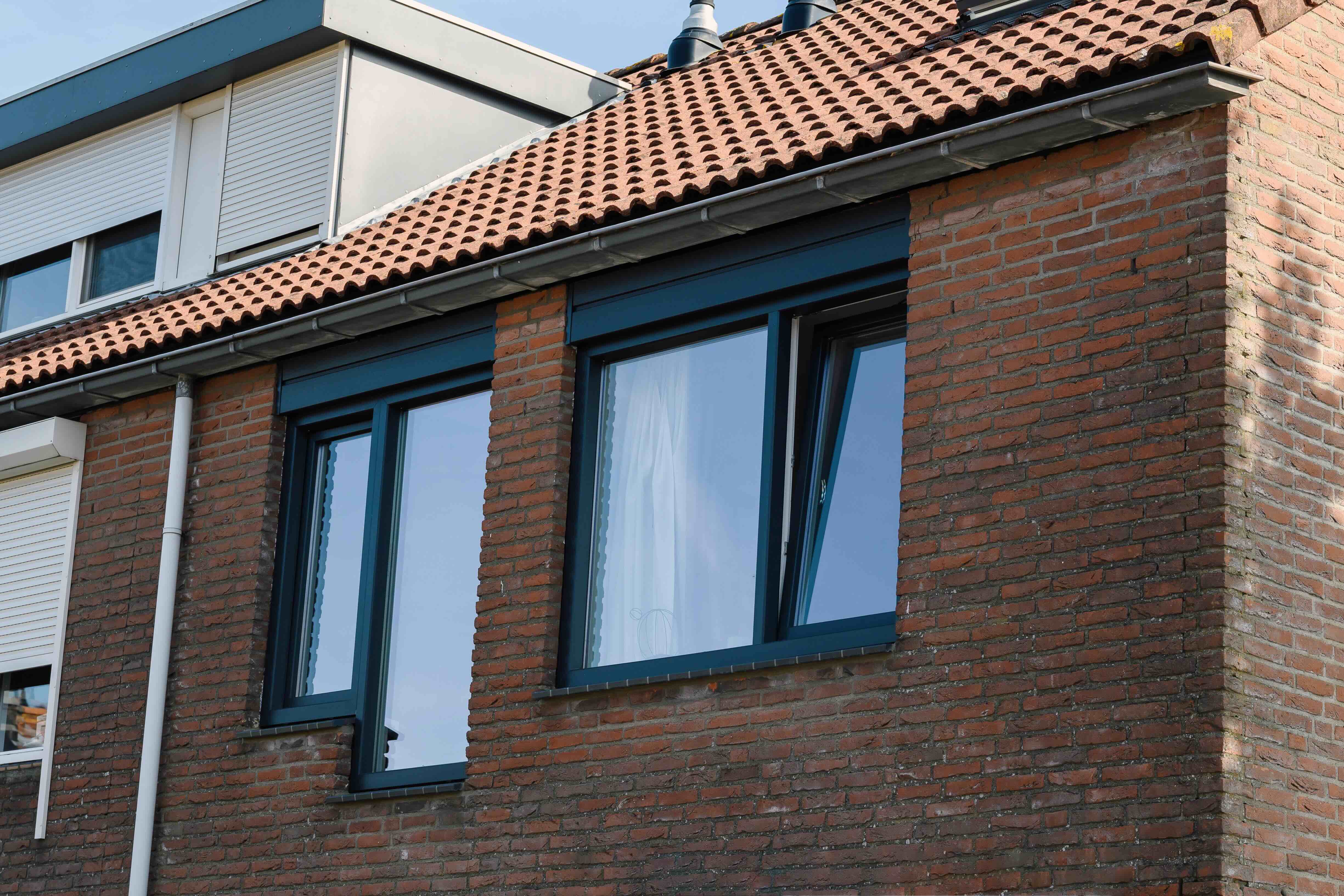 Donkere kunststof kozijnen met isolerende beglazing in een gerenoveerde woning